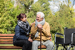 Fille avec son père en fauteuil roulant dans un parc.